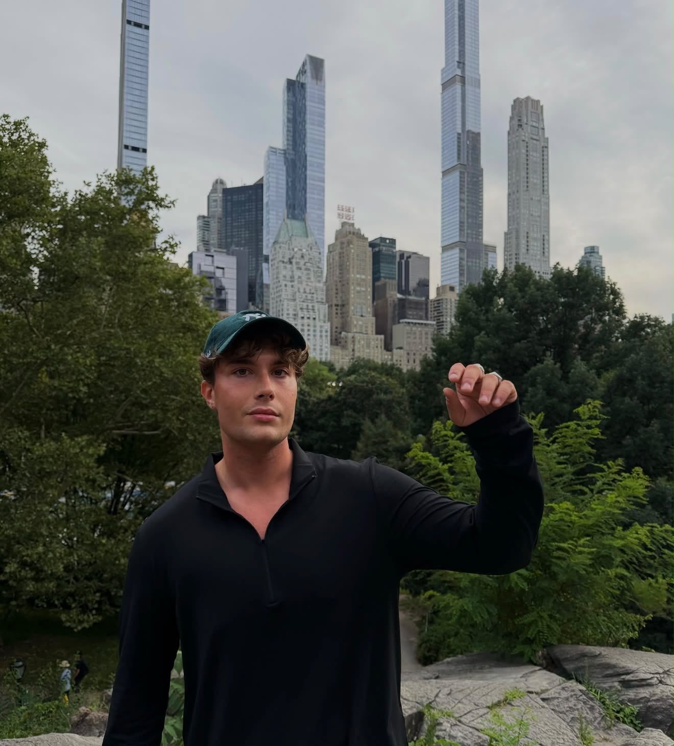 Dominik w czapce z daszkiem na tle wieżowców Manhattanu widzianych z Central Parku